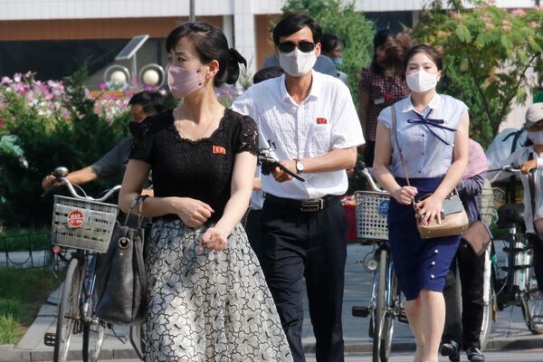 People wearing masks walk in the Ryomyong street in Pyongyang, North Korea on Friday. North Korean leader Kim Jong Un urged officials to maintain alertness against the coronavirus.