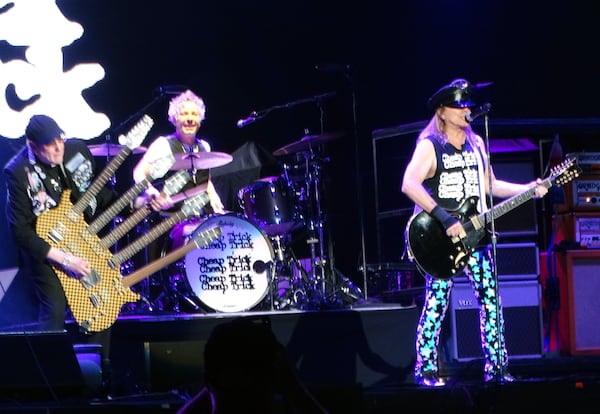 Rick Nielsen (left), his son Daxx Nielsen at drums and lead singer Robin Zander, finish out their Ameris set in Alpharetta August 31, 2022 with "Goodnight." RODNEY HO/rho@ajc.com