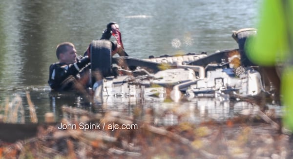 A diver checks out the wreckage Monday in a pond near the Flint River. JOHN SPINK / JSPINK@AJC.COM