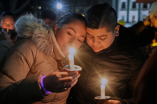 Supporters hold candles during a candlelight vigil Tuesday, Dec. 17, 2024, outside the Wisconsin Capitol in Madison, Wis., following a shooting at the Abundant Life Christian School on Monday, Dec. 16. (AP Photo/Morry Gash)