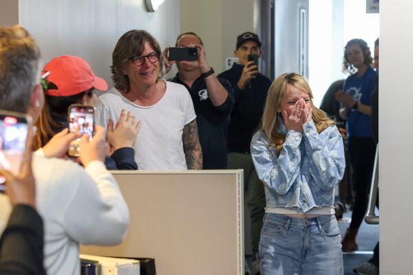 Kevin Avery (left) and Taylor Scott are congratulated by co-workers following their final broadcast of the Kevin & Taylor Show at the Fish 104.7 inside their studio on Friday, Jan. 31, 2025, in Atlanta. (Jason Getz/AJC)