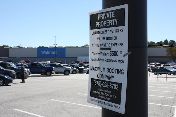 Booting is outlawed in some Georgia counties and governed by ordinance in some cities, including Atlanta. In other areas, booting companies make the rules. A sign in the Newnan Crossing shopping center in Newnan, Ga., warns owners of “unauthorized vehicles” they are subject to booting. (AJC file photo)