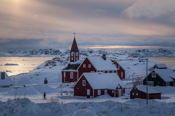 FILE - A woman walks near a church in Nuuk, Greenland, Friday, March 7, 2025. (AP Photo/Evgeniy Maloletka, File)