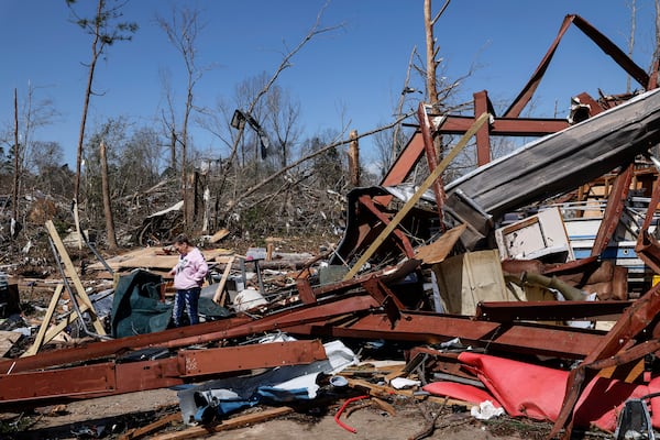 Friends and family members search for belongings in the damage after a tornado passed through the area, Sunday, March 16, 2025, in Plantersville, Ala. (AP Photo/Butch Dill)