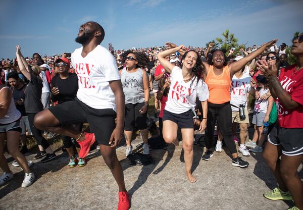 David Bryant (L) and Adelaide Leao (C) worship together during the start of the OneRace event on top of Stone Mountain Saturday. STEVE SCHAEFER / SPECIAL TO THE AJC