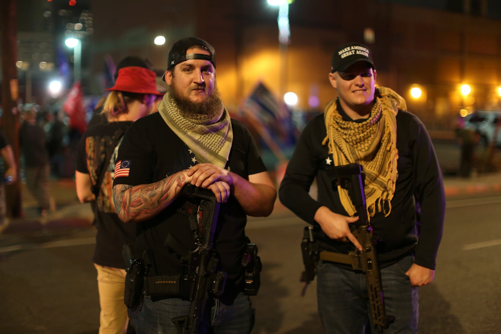 FILE - Armed supporters of President Donald Trump stand outside the Maricopa County Recorder's Office where votes in the general election are being counted, in Phoenix, Nov. 6, 2020. The man at left, who did not want to give his name, says he came armed to the pro-Trump protest to "exercise his common Second Amendment right." (AP Photo/Dario Lopez-MIlls, File)