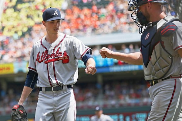 Braves' pitcher Max Fried, left, gets a fist bump from catcher Tyler Flowers after Minnesota Twins' catcher Mitch Garver flew out to end the fifth inning. (AP Photo/Jim Mone)