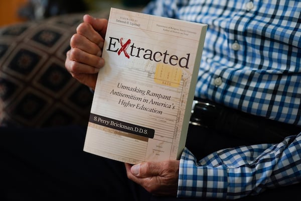 Perry Brickman holds a copy of his book,.”Extracted: Unmasking Rampant Antisemitism in America’s Higher Education.” ELIJAH NOUVELAGE/SPECIAL TO THE AJC