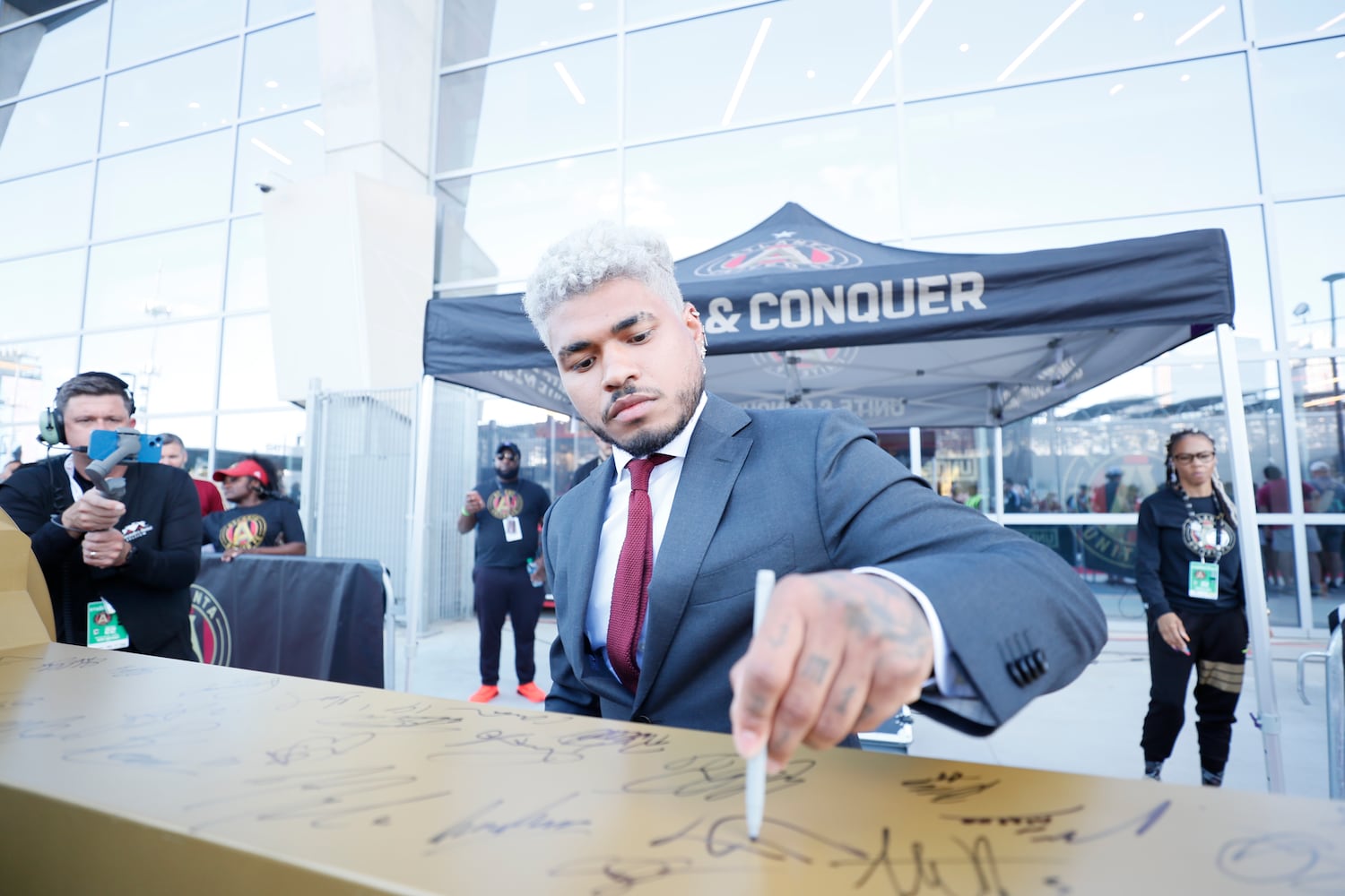 Atlanta United forward Josef Martinez signs the golden spike as the team arrives at the Mercedes-Benz Stadium before the game against the Columbus Crew on Saturday, May 28, 2022.