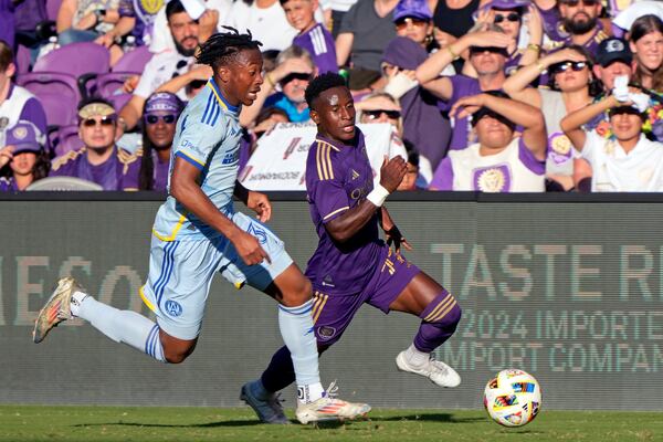 Orlando City's Ivan Angulo, right, moves the ball as Atlanta United's Ajani Fortune, left, defends during the first half of an MLS Semifinal Conference playoff soccer match, Sunday, Nov. 24, 2024, in Orlando, Fla. (AP Photo/John Raoux)