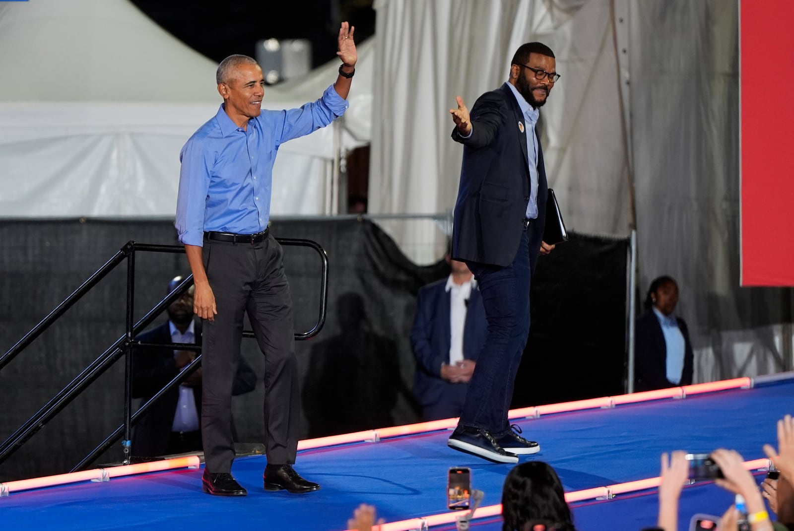 Former President Barack Obama waves to the crowd as Tyler Perry leaves the stage after speaking during a campaign rally supporting Democratic presidential nominee Vice President Kamala Harris on Thursday, Oct. 24, 2024, in Clarkston, Ga. (AP Photo/Mike Stewart)