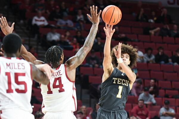 Georgia Tech guard Naithan George (1) passes over Oklahoma forward Jalon Moore (14) during the second half of an NCAA college basketball game, Tuesday, Dec. 3, 2024, in Norman, Okla. (AP Photo/Kyle Phillips)