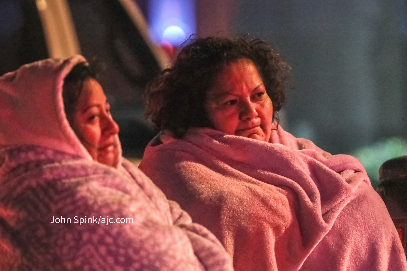 Reyna Arangon (left) and Claudia Maldonado wait for the Red Cross in freezing temperatures after a fire engulfed their apartment building Wednesday morning.