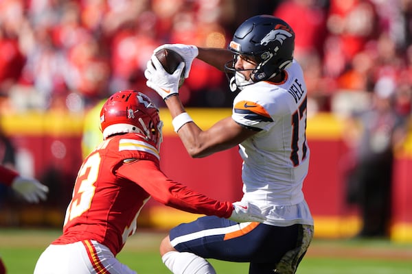 Denver Broncos wide receiver Devaughn Vele (17) catches a pass as Kansas City Chiefs safety Nazeeh Johnson (13) defends during the first half of an NFL football game Sunday, Nov. 10, 2024, in Kansas City, Mo. (AP Photo/Charlie Riedel)