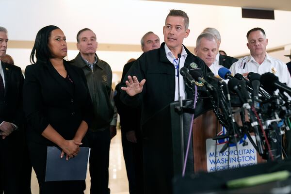 Transportation Secretary Sean Duffy, with District of Columbia Mayor Muriel Bowser, left, and others, speaks during a news conference at Ronald Reagan Washington National Airport, Thursday morning, Jan. 30, 2025, in Arlington, Va. (AP Photo/Mark Schiefelbein)