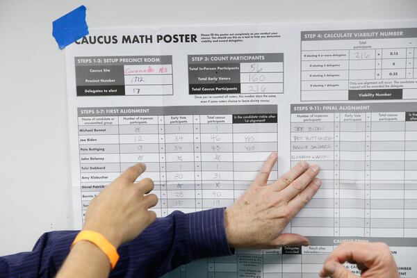 Caucus-goers look over vote numbers at Coronado High School in Henderson, Nevada, on Saturday.