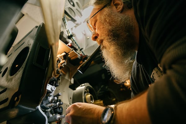 John Woodson, a projectionist at the Tara Theatre in Atlanta, loads a 35mm film reel for a showing of Anora on Friday, March 7, 2025. (Olivia Bowdoin for the AJC). 