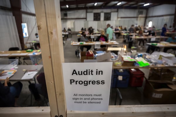 Chatham County Board of Elections officials post signs in the public viewing area during a statewide audit of ballots from the 2020 election. (AJC Photo/Stephen B. Morton)