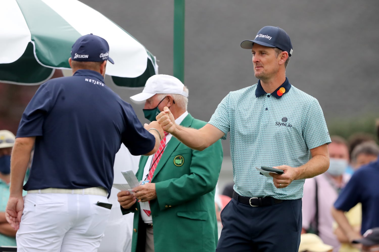 April 9, 2021, Augusta: Justin Rose, right, gets a fist bump from Shane Lowry before their second round on the first hole during the Masters at Augusta National Golf Club on Friday, April 9, 2021, in Augusta. Curtis Compton/ccompton@ajc.com