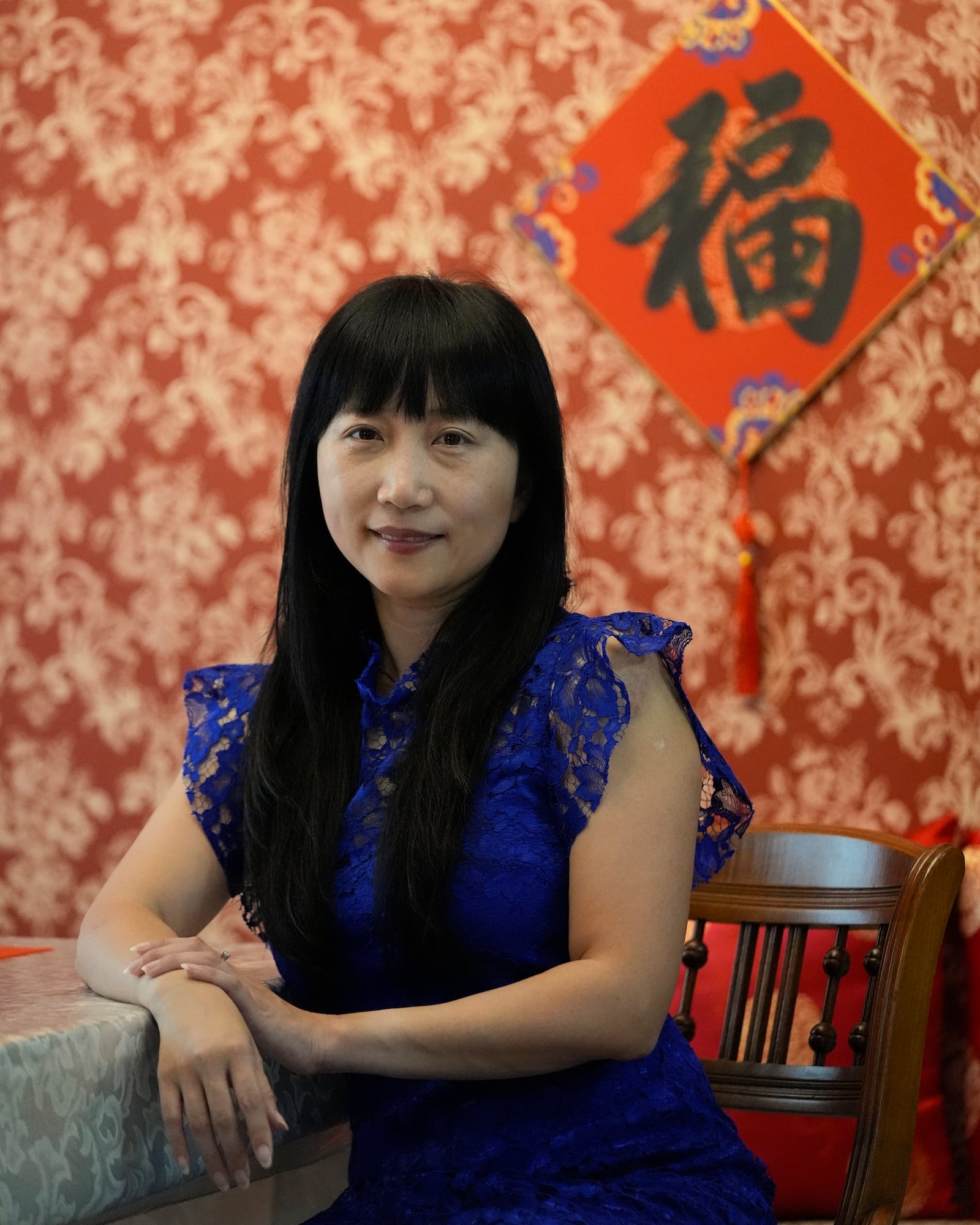 Diana Xue poses for a photo at her home Monday, Oct. 21, 2024, in Orlando, Fla. Xue is a naturalized U.S. citizen born in China who used to vote more Republican but has changed her mind after Florida passed the alien land law. (AP Photo/John Raoux)