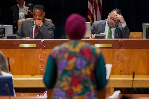 New Orleans city council members Eugene J. Green, left, and JP Morrell, listen as Candice Henderson-Chandler, who purchased the former home of civil rights leader Oretha Castle Haley and plans to open a museum, speaks during a city council hearing on the matter, which is opposed by Castle Haley's family, in New Orleans, Thursday, Oct. 24, 2024. (AP Photo/Gerald Herbert)