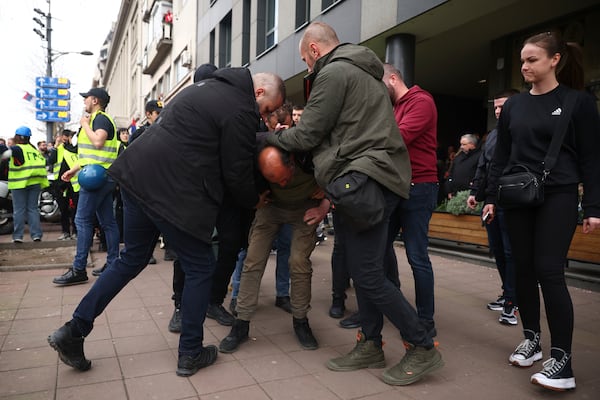 A man who allegedly claimed he was armed with bombs is detained by plain clothed police during a major rally against populist President Aleksandar Vucic and his government, in downtown Belgrade, Serbia, Saturday, March 15, 2025. (AP Photo/Armin Durgut)