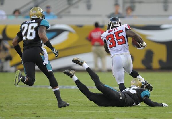 Atlanta Falcons running back Antone Smith (35) breaks away from Jacksonville Jaguars defensive back Sherrod Martin, center, and free safety Josh Evans (26) for a 66-yard touchdown after a reception during the first half of an NFL preseason football game in Jacksonville, Fla., Thursday, Aug. 28, 2014. (AP Photo/Stephen B. Morton)