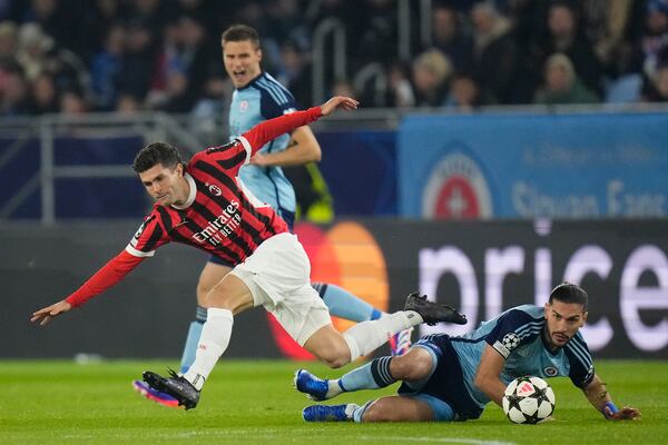 AC Milan's Christian Pulisic (left) and Slovan's Kyriakos Savvidis fight for the ball during the Champions League opening match between Slovan Bratislava and AC Milan in Bratislava, Slovakia on Tuesday, November 26, 2024. (AP Photo/Petr David Josek)