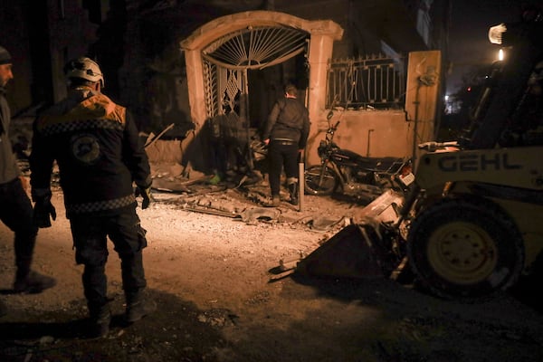 Residents inspect the site of an air strike in Idlib, Syria, Sunday Dec. 1, 2024. Government airstrikes in Idlib killed at least three civilians, including two children, and wounded 11 others, said the Syrian Civil Defense, known as the White Helmets, which operates in opposition-held areas. (AP Photo/Omar Albam)