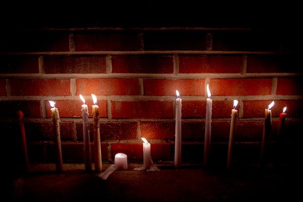 Candles are left lighted next to a wall of a Family Dollar store to honor Calvin Munerlyn on Sunday in Flint, Michigan.