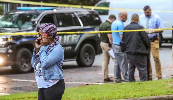 A distressed woman makes a phone call at the scene of a death investigation in the East Ponce Village apartment complex Thursday morning. She did not want to be identified but said she knew the victim.