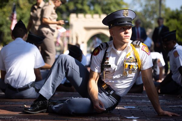 Georgia Military College student Will Brantley writes the names of Sept. 11 victims on his Milledgeville campus' pathway. (Arvin Temkar / arvin.temkar@ajc.com)