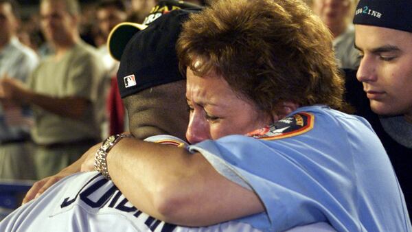 Braves outfielder Brian Jordan hugs Carol Gies, who lost her firefighter husband in the World Trade Center attack, before game against the N.Y. Mets - the first sporting event since the tragedy - Friday, Sept. 21, 2001, at Shea Stadium in New York. (Phil Skinner/AJC)