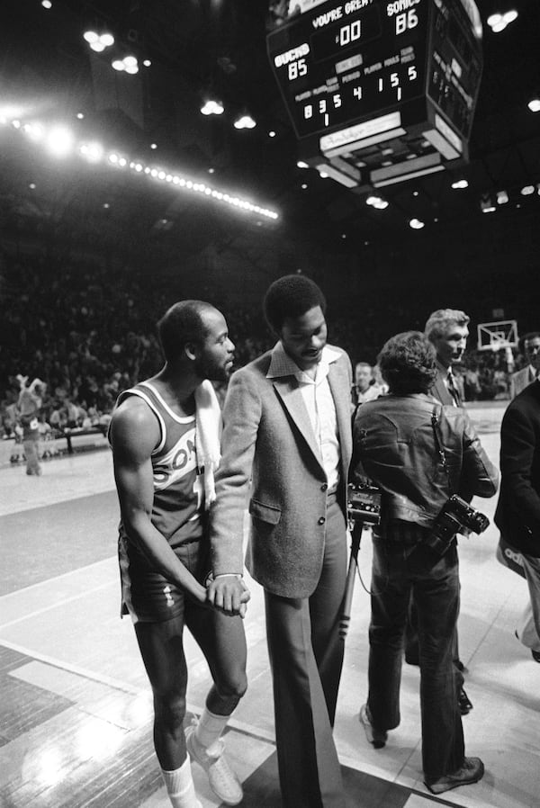 FILE - Seattle's Gus Williams holds Milwaukee's Junior Bridgeman's hand as they walk off the court following the Supersonics' 86-85 victory in NBA playoff action, April 19, 1980 in Milwaukee. (AP Photo/Steve Pyle, File)