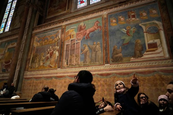 People admire Giotto's frescoes inside St. Francis Basilica in Assisi, Italy, Saturday, March 1, 2025. (AP Photo/Gregorio Borgia)