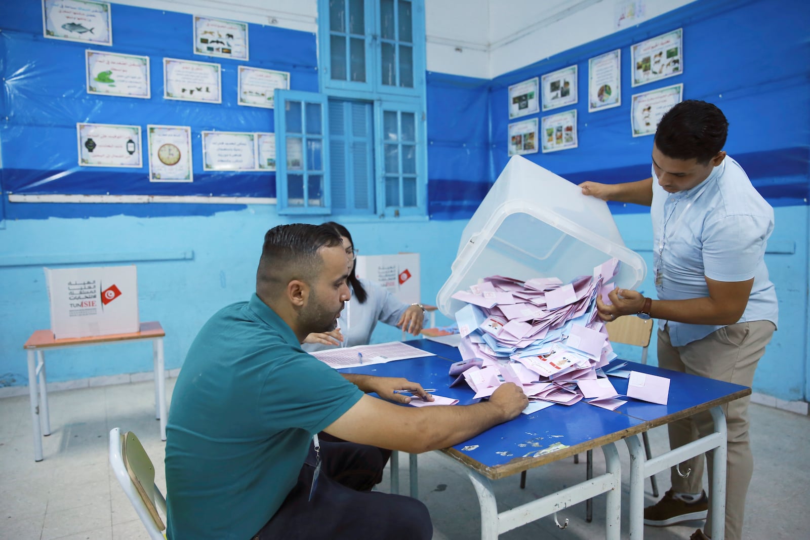 Election officials open a ballot box to count votes after the presidential elections, in the capital Tunis, Tunisia, Sunday, Oct. 6, 2024. (AP Photo/Anis Mili)