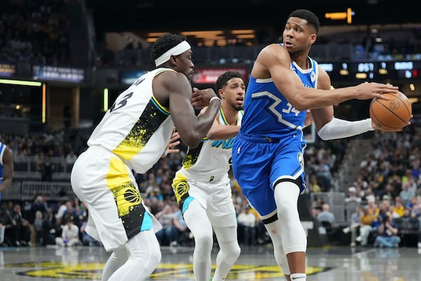 Milwaukee Bucks forward Giannis Antetokounmpo, right, passes around Indiana Pacers forward Pascal Siakam during the first half of an NBA basketball game in Indianapolis, Tuesday, March 11, 2025. (AP Photo/AJ Mast)