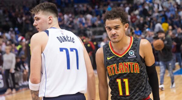 Dallas Mavericks forward Luka Doncic (77) and Hawks guard Trae Young pass in the night following their game Wednesday.