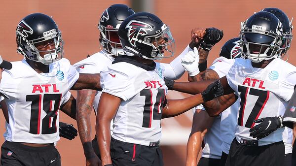 The Falcons' wide receivers group, including Calvin Ridley (from left), Russell Gage and Olamide Zaccheaus give each other a fist bump as they take the field for the first day of practice during training camp Thursday, July 29, 2021, at the team's training facility in Flowery Branch. (Curtis Compton / Curtis.Compton@ajc.com)