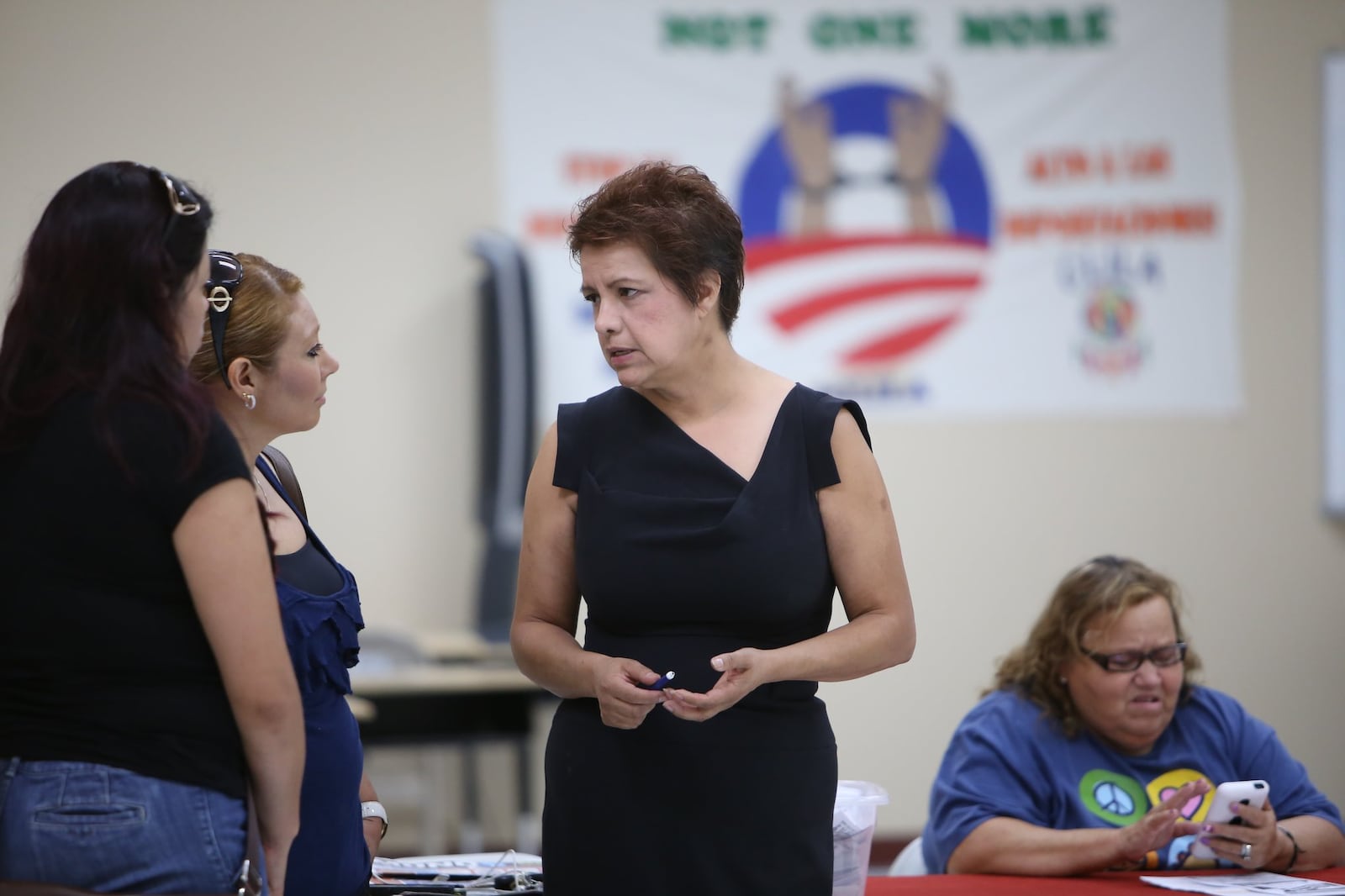 America Gruner (in black), president of the Coalition of Latino Leaders (CLILA), speaks to prospective voters at the organization’s headquarters in Dalton, Ga.