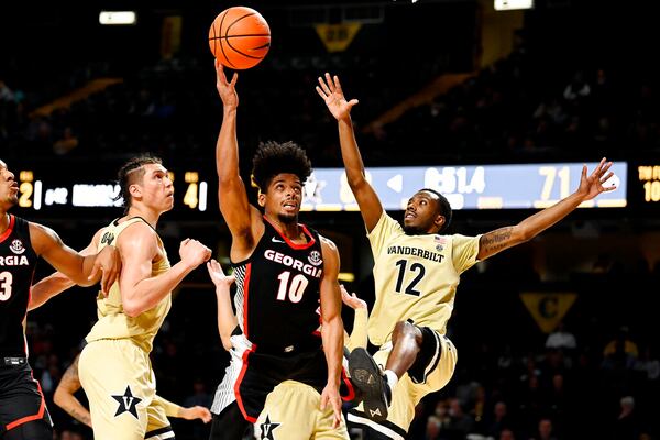 Georgia guard Aaron Cook (10) drives between Vanderbilt forward Quentin Millora-Brown, second from left, and guard Trey Thomas (12) during the second half of an NCAA college basketball game against Saturday, Jan. 29, 2022, in Nashville, Tenn. (AP Photo/Mark Zaleski)