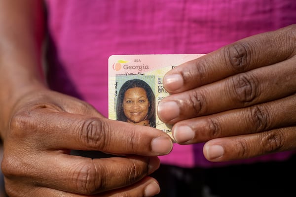 South Fulton resident Courtney Brown holds her Georgia driver's license. Brown is one of over 272,000 state voters who would have to submit some other form of ID, such as a utility bill or bank statement, to cast an absentee ballot, according to Georgia’s new voting law.  (Alyssa Pointer / Alyssa.Pointer@ajc.com)