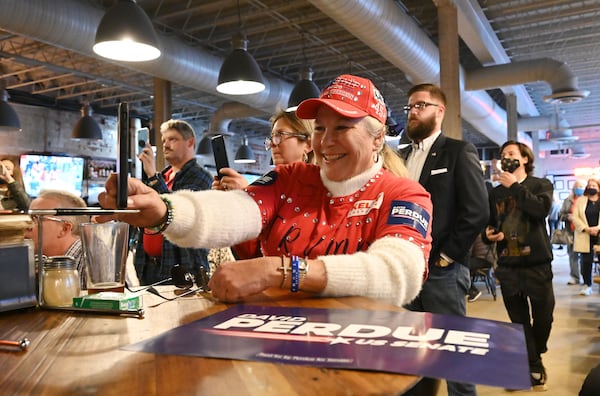 December 30, 2020 Dalton - Roberta Sikkelee Curtin, of Dalton, reacts as she takes a photograph of U.S. Sen. David Perdue during a campaign event at Cherokee Brewing + Pizza Company in downtown Dalton on Wednesday, December 30, 2020. The North Georgia county now has the highest infection rate among GeorgiaÕs 159 counties, with one in 10 Whitfield residents testing positive for COVID-19. Seeking to boost Republican turnout for GeorgiaÕs U.S. Senate runoffs, President Donald Trump is planning to hold a rally Monday at the regional airport in Dalton, an event organizers expect will attract as many as 20,000 people. (Hyosub Shin / Hyosub.Shin@ajc.com)