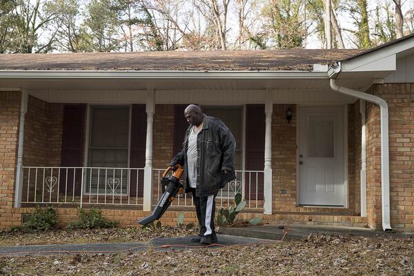 Jerard Morton blows leaves in his front yard at the Loch Lomond Estates neighborhood subdivision in South Fulton. (ALYSSA POINTER/ALYSSA.POINTER@AJC.COM)