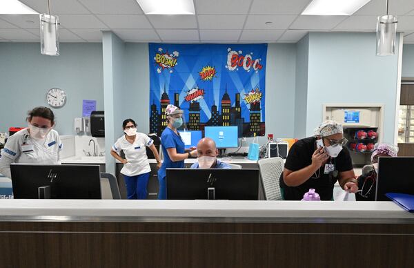 Medical staff work in one of the COVID-19 wards at Memorial Health's Heart and Vascular Institute in Savannah. Dr. John Watson, an ICU physician, says "Sometimes it is easier to just stay busy and keep looking for the next person to try to help ... than it is to actually reflect on the impact that it may have on me or my family." (Hyosub Shin / Hyosub.Shin@ajc.com)