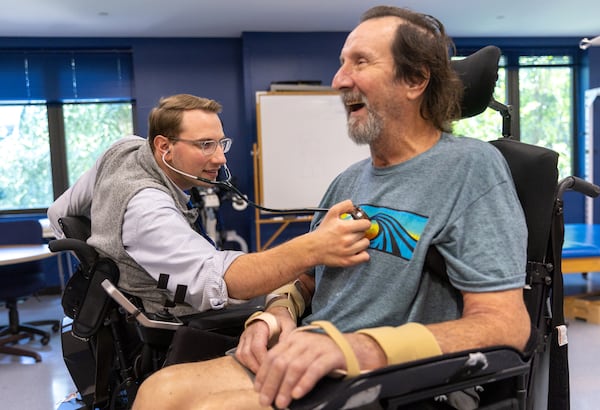 Dr. Woody Morgan, left, examines patient Lucky Hardy, 65, at Shepherd Center, says, "I didn’t know when I got here my doctor would be in a wheelchair. I just knew I was going to see Dr. Morgan. But I felt a connection like maybe he can feel my pain. He knows what I am going through." (Arvin Temkar / arvin.temkar@ajc.com)