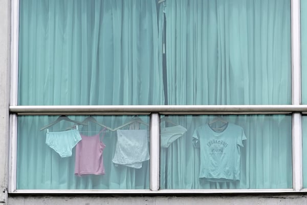 Clothes hang in the window of a hotel room where authorities have housed migrants deported from the United States in Panama City, Friday, Feb. 21, 2025. (AP Photo/Matias Delacroix)