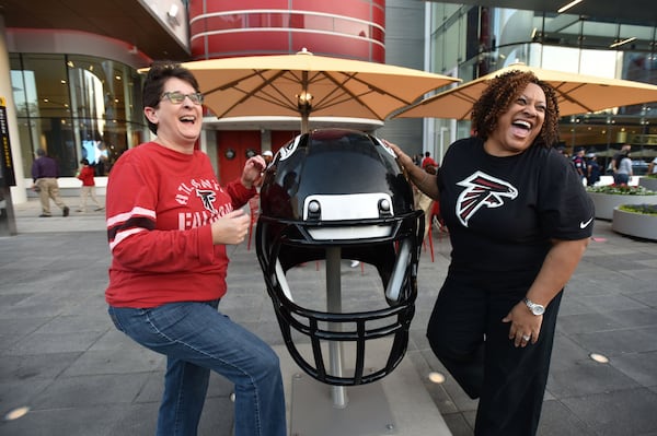 Atlanta Falcons fans from Atlanta Jill Shrader (left) and Lisa Smith pose with Falcons’ helmet as they visit the 2017 Super Bowl 51 - NFL Experience outside the convention center in Houston on Wednesday. (Hyosub Shin / hshin@ajc.com)