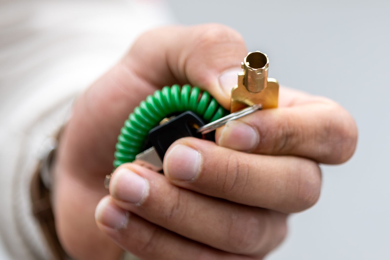 Christian Verrette poses with the key he made that unlocks most of the car boots in Atlanta Tuesday, May 9, 2023 (Steve Schaefer/steve.schaefer@ajc.com)