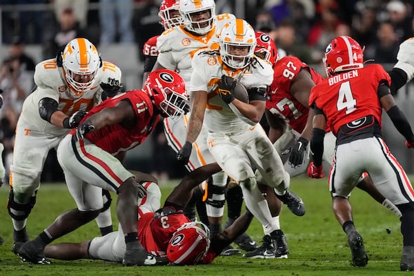 Tennessee running back Peyton Lewis (27) tries to brel free from Georgia's CJ Allen (3) and Jalon Walker (11) during the first half of an NCAA college football game, Saturday, Nov. 16, 2024, in Athens, Ga. (AP Photo/John Bazemore)